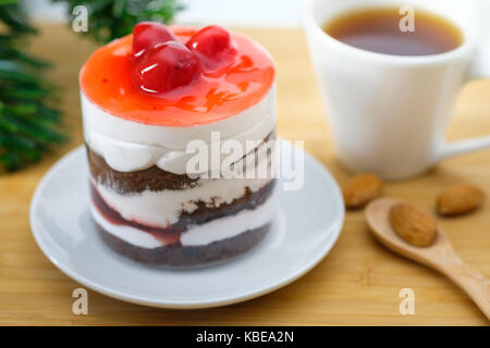 Fraises au chocolat avec crème blanche et cerise sur table en bois, une cuillère en bois et de la pâte d'amandes fermer, close-up Banque D'Images