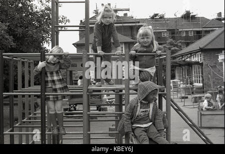 Années 1970, historiques, les jeunes enfants sur un mur d'escalade extérieur à une pépinière de Londres sur un ensemble immobilier conseil à Deptford, Londres du sud, Englad, Royaume-Uni. Banque D'Images