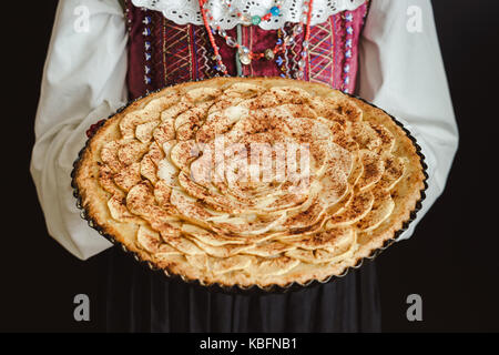 Tarte aux pommes maison en mains de femme portant costume traditionnelle ukrainienne Banque D'Images