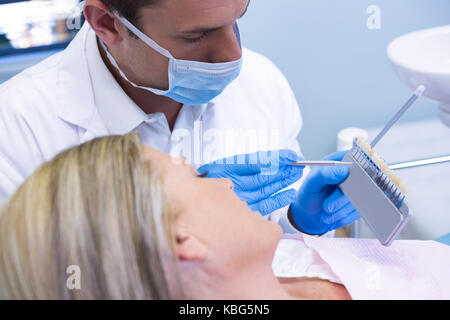 Portrait de dentiste montrant l'équipement à la clinique médicale au patient Banque D'Images