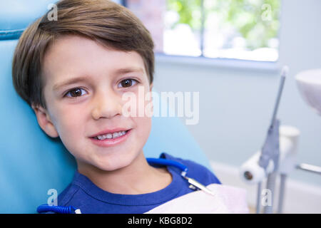 Portrait of cute boy sitting on chair à une clinique dentaire Banque D'Images