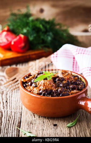 Bol de chili avec haricots noirs, beaf ragoût de viande dans le bol en céramique tableau par pays Banque D'Images