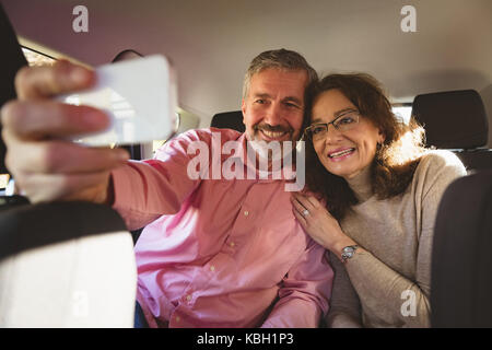 Couple heureux en tenant en selfies location Banque D'Images