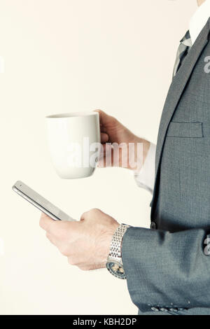Homme sans tête profil professionnel vue latérale à l'aide de smart mobile phone tout en tenant une tasse de café à la verticale. portrait de bureau Banque D'Images