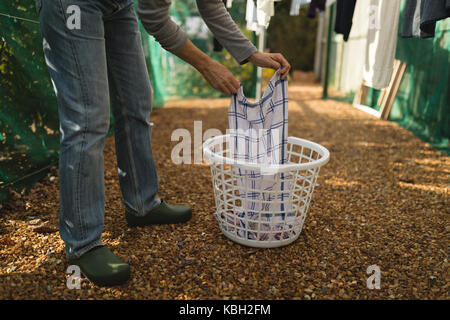 Senior woman étendre le linge sur la corde à linge sur une journée ensoleillée Banque D'Images