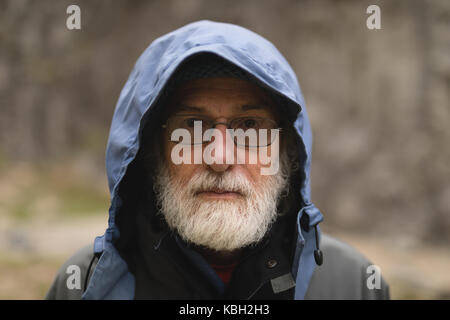 Portrait of senior man standing in front of mountain Banque D'Images