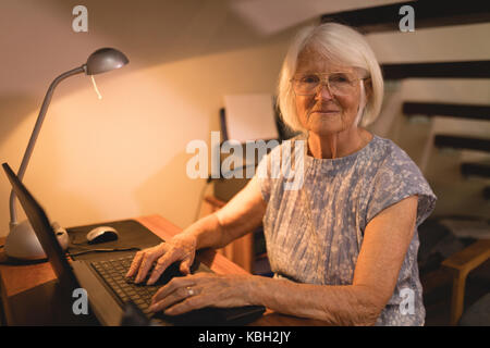 Portrait of senior woman working on laptop at home Banque D'Images