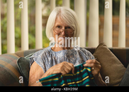 Portrait of senior woman laine à tricoter dans le séjour à la maison Banque D'Images