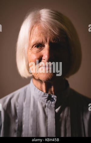 Portrait of senior woman contre fond brun Banque D'Images