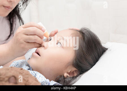 Close up mère les gouttes dans les yeux de la jeune fille une solution médicinale, concept de soins en santé Banque D'Images