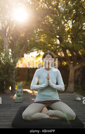 Senior woman practicing yoga dans le parc en été Banque D'Images