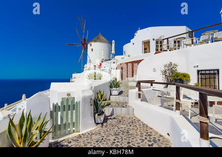 Oia, Santorin, Grèce. célèbres moulins à vent sur la falaise, cobled rues et maisons blanches sur la caldeira, la mer Égée. Banque D'Images