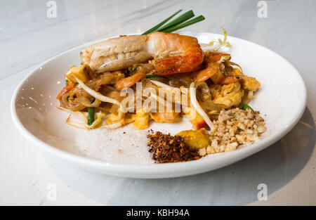 Bâtonnets de riz frit aux crevettes (pad thaï goong sod) mettre une plaque blanche et placés sur une table de marbre blanc.Il s'agit d'une alimentation populaire de manger en arrivant à t Banque D'Images