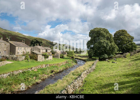 Le village de thwaite dans swaledale, Yorkshire Dales, Angleterre. maisons à côté de l'eau. Un emplacement sur le Pennine Way. Banque D'Images