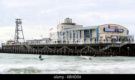 Un surfeur au large de la plage de Boscombe Bournemouth, Grande-Bretagne, comme on est en bonne voie pour fortes pluies et tempêtes comme vestiges de l'ouragan lee ajouter "oomph" à un système de basse pression se déplaçant à travers l'Atlantique, les prévisionnistes dit. Banque D'Images