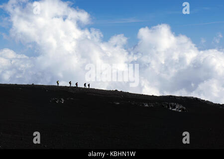 Les touristes silhouettes sur le bord du chemin sur l'etna, en Sicile, Italie Banque D'Images