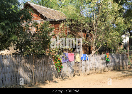 Séchage de blanchisserie au sommet d'une clôture à côté d'une maison à Salay Village sur les rives de l'Irrawaddy au Myanmar (Birmanie). Banque D'Images