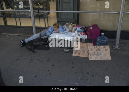 Femme sans-abri et son chien s'est écrasé sur le trottoir avec signe de demander de l'aide. La ville de New York. Banque D'Images