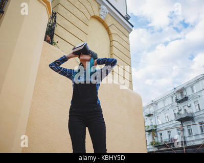 Street punk ou hipster girl avec les cheveux teints en bleu s'amusant avec lunettes vr sans souci.. concept concept de réalité virtuelle. Le mouvement lent. Banque D'Images