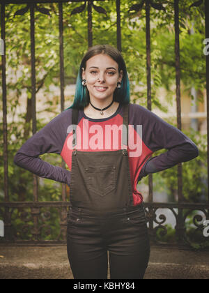 Street punk ou hipster girl enjoying vide vieille rue européenne. portrait de teen girl with blue,cheveux teints en violet piercing nez,lentilles et inhabituelle h Banque D'Images