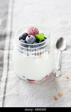 Parfait au yogourt avec granola, les framboises et les bleuets dans un bocal. concept de saine alimentation, régimes, mode de vie sain et équilibré. libre de vi Banque D'Images