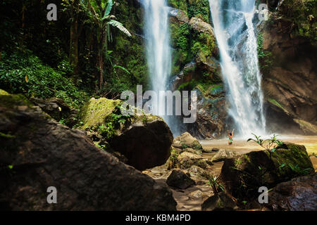 Belle jeune femme voyage cascade excité cachés dans la jungle tropicale Banque D'Images