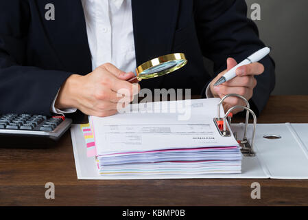 Portrait de femme l'examen comptable des factures avec loupe à 24 Banque D'Images