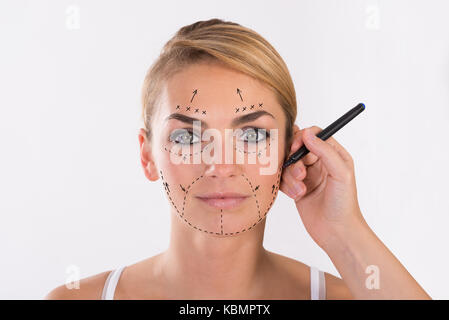 Portrait de jeune femme en cours de lifting sur fond blanc Banque D'Images