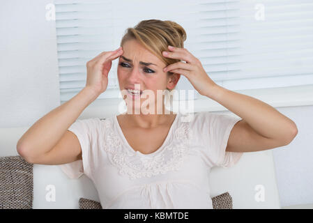 Portrait de jeune femme souffrant de maux de tête à la maison Banque D'Images