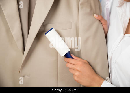 Close-up of woman manteau avec rouleau adhésif Banque D'Images