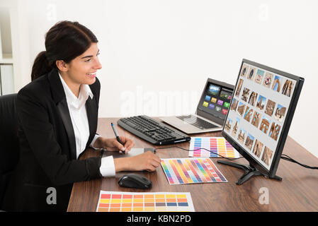 Young female graphiste à bureau. photographe est propriétaire de copyright pour les images à l'écran Banque D'Images