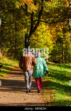 Vieux couple marchant sur un chemin dans un parc Banque D'Images