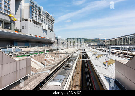 La gare de Kyoto. Vue de dessus, en attente du train en toiture plate-forme couverte, à gauche le bâtiment de la gare et l'Hôtel Granvia. Soleil, ciel bleu. Banque D'Images