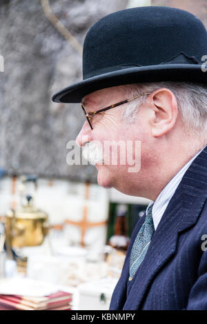 En Angleterre, Chatham. Re-enactment. Vieil Homme avec moustache grise et des lunettes, vêtu de noir chapeau melon. Vue latérale. Vers les années 1940. Tête et épaules. Banque D'Images