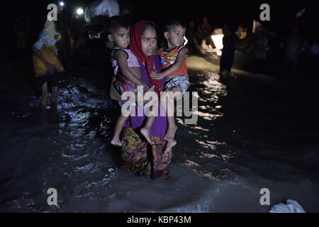 Cox's bazar, BANGLADESH - septembre 30, 2017 : sur une nuit sombre Myanmar Rohingyas réfugiés musulmans en situation minoritaire de la descendre d'un bateau sur la banque de naf riv Banque D'Images