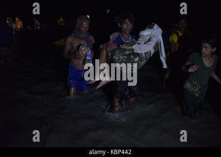 Cox's bazar, BANGLADESH - septembre 30, 2017 : sur une nuit sombre Myanmar Rohingyas réfugiés musulmans en situation minoritaire de la descendre d'un bateau sur la banque de naf riv Banque D'Images