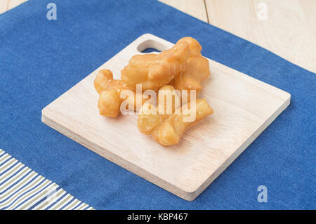 Des snacks traditionnels chinois frits (doughstick pa tong rendez) sur la plaque en bois.(soft focus) Banque D'Images