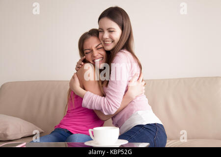 Deux happy smiling young girlfriends donnant à chaque autre gros câlin. Banque D'Images