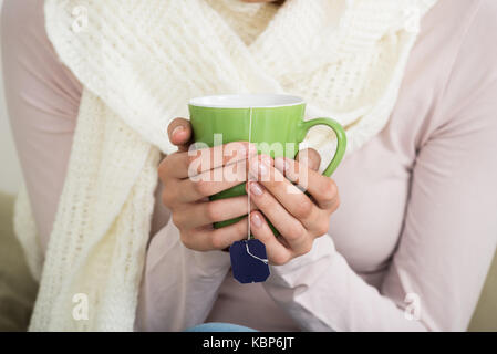 Portrait of young woman holding tee mug à la maison Banque D'Images
