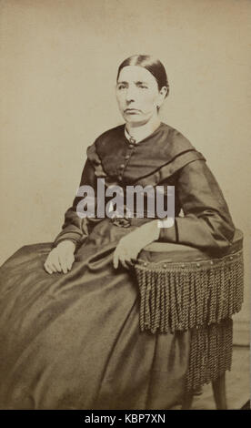 Archive américaine studio monochrome portrait photographique de femme plus âgée avec stern expression assis sur une chaise et portant une robe sombre, nommée Matilda Gage, prises à la fin du 19e siècle par Gilmore's Gallery of Art, Binghamton, NY, USA Banque D'Images