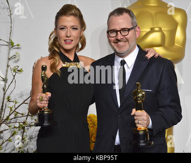 Caitlin Rogers et Morgan Neville posent dans la salle de presse lors du 86e prix annuel de l'Académie à l'hôtel Loews Hollywood le 2 mars 2014 à Hollywood, Californie. Banque D'Images