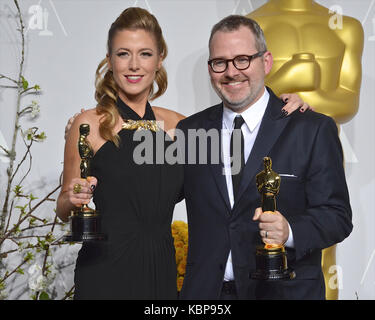 Caitlin Rogers et Morgan Neville posent dans la salle de presse lors du 86e prix annuel de l'Académie à l'hôtel Loews Hollywood le 2 mars 2014 à Hollywood, Californie. Banque D'Images