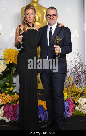 Caitlin Rogers et Morgan Neville posent dans la salle de presse lors du 86e prix annuel de l'Académie à l'hôtel Loews Hollywood le 2 mars 2014 à Hollywood, Californie. Banque D'Images