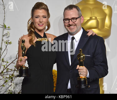 Caitlin Rogers et Morgan Neville posent dans la salle de presse lors du 86e prix annuel de l'Académie à l'hôtel Loews Hollywood le 2 mars 2014 à Hollywood, Californie. Banque D'Images