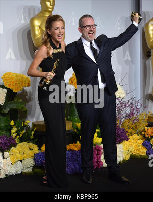 Caitlin Rogers et Morgan Neville posent dans la salle de presse lors du 86e prix annuel de l'Académie à l'hôtel Loews Hollywood le 2 mars 2014 à Hollywood, Californie. Banque D'Images