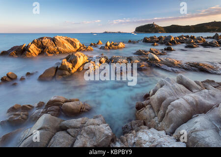 Coucher de soleil sur le récif de Porto Giunco plage et la vieille tour, Villasimius, Cagliari, Sardaigne, Italie, Europe.