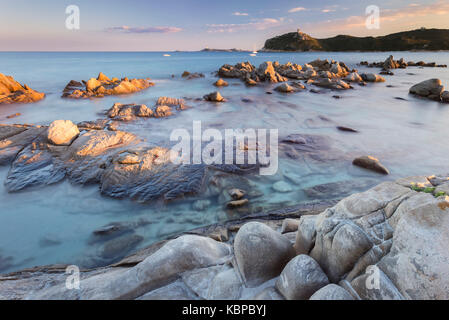 Coucher de soleil sur le récif de Porto Giunco plage et la vieille tour, Villasimius, Cagliari, Sardaigne, Italie, Europe.