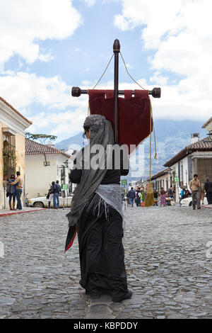 14 février 2015 Antigua Guatemala : Jeune femme tenant une croix coloniale sur la rue pavée de la ville touristique populaire Banque D'Images