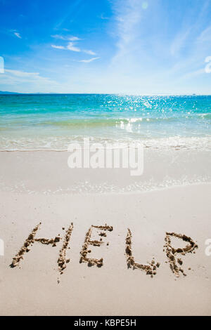 Help sign sur la plage de sable sur l'écrit Banque D'Images