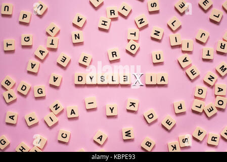 Concept de la dyslexie - lettres de l'alphabet sur fond rose Banque D'Images